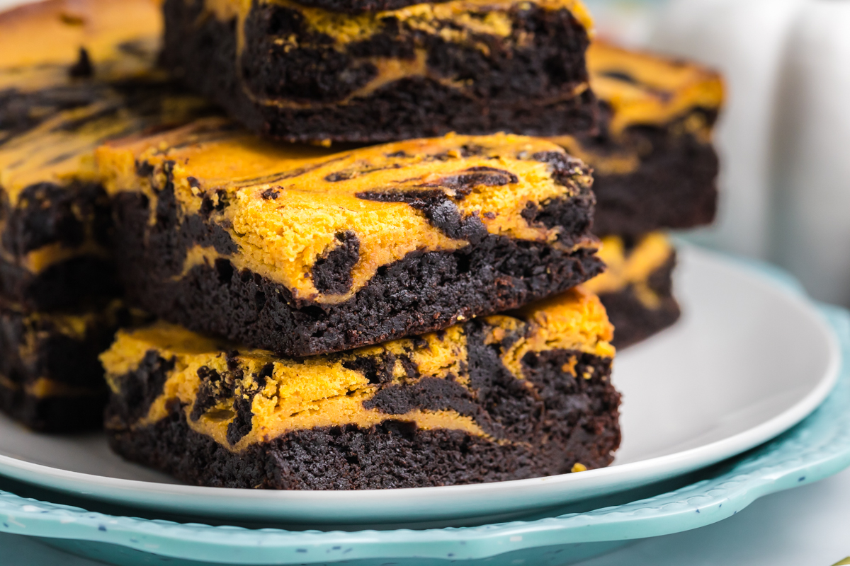 close up straight on shot of plate of pumpkin cheesecake brownies