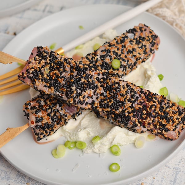 overhead shot of two sticks of sesame crusted tuna on a plate