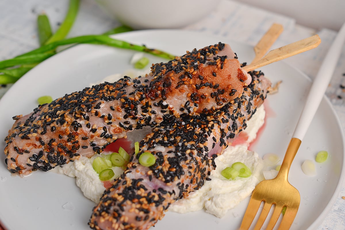 two sticks of sesame crusted tuna on a plate