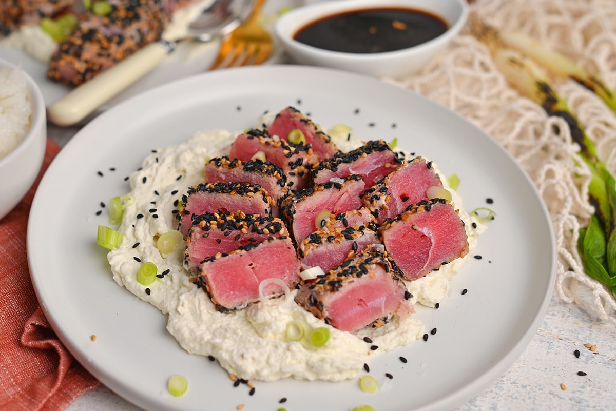 angled shot of sliced sesame crusted tuna over mashed cauliflower on a plate