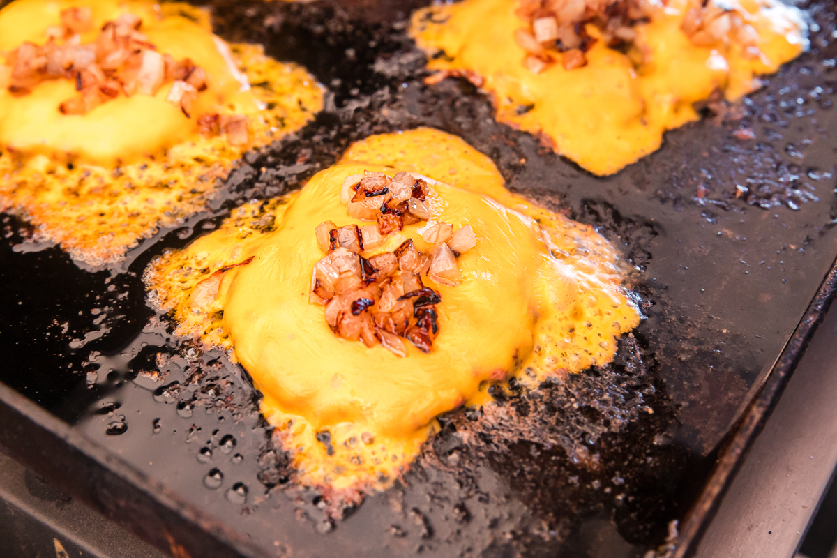 cheese and onions on burger patties