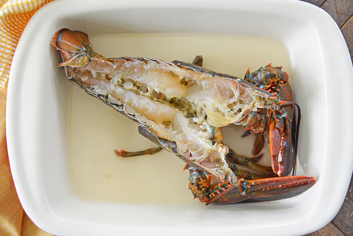 halved lobster in a baking dish