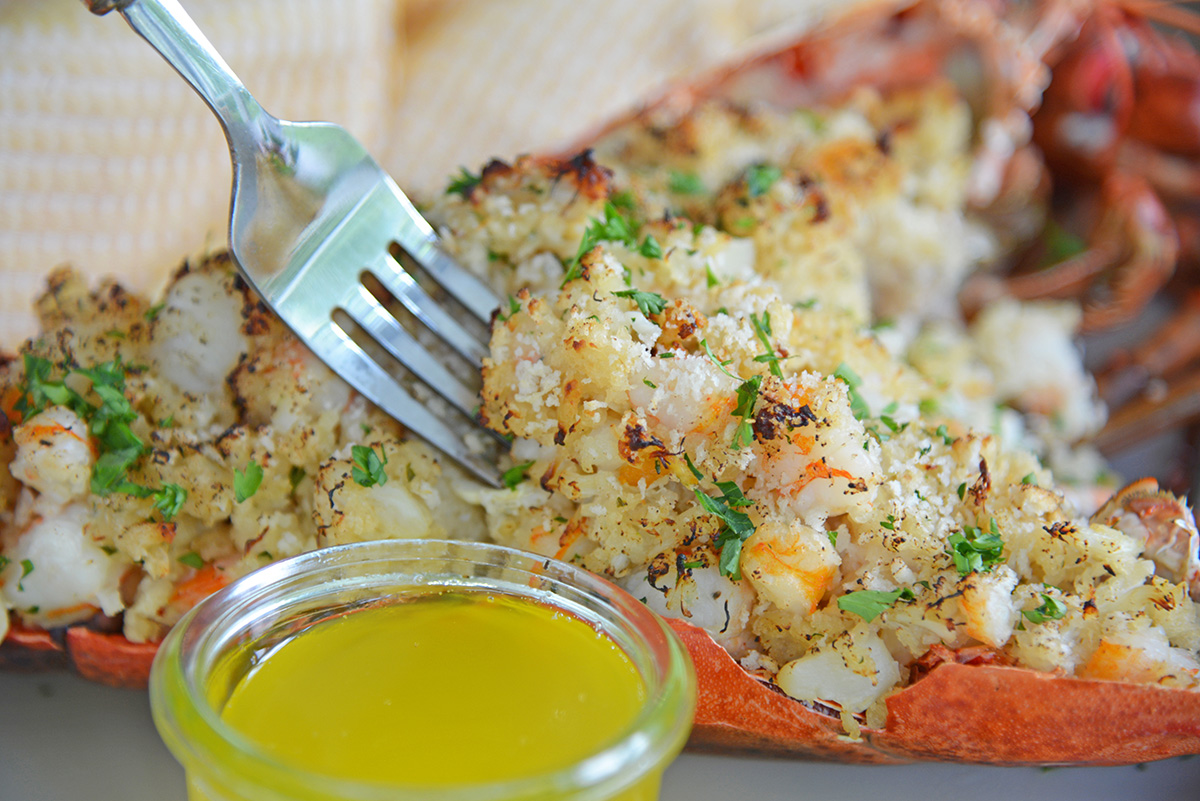 fork digging into a seafood stuffed lobster