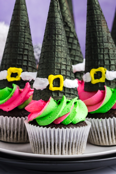 plater of green and pink frosted witch hat cupcakes