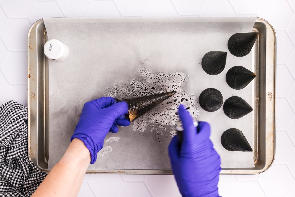 hands spraying sugar cones with food spray