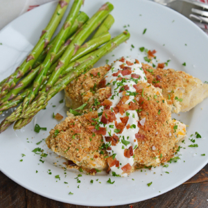 angled shot of bacon ranch chicken on plate with asparagus