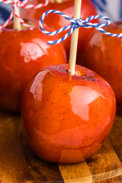 close up angled shot of candied apples on wooden board