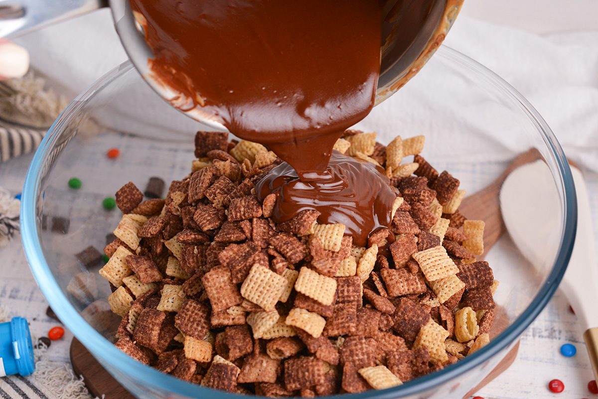 melted chocolate pouring over bowl of chex with chocolate 