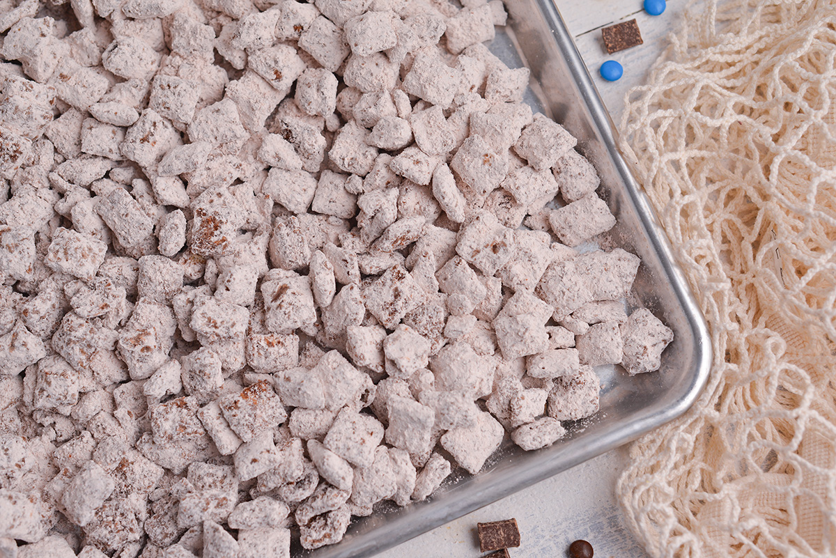 close up shot of chocolate puppy chow on baking sheet