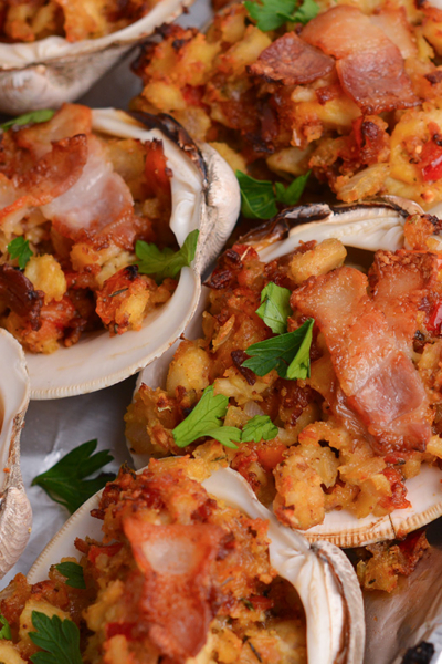 close up angled shot of clams casino topped with bacon