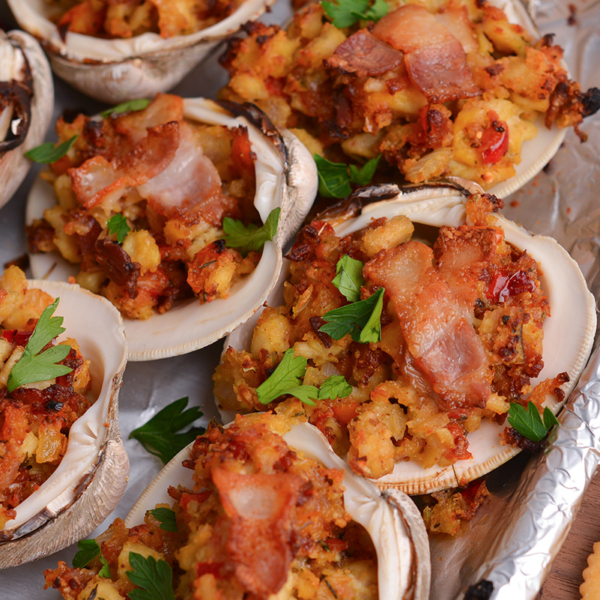 close up angled shot of clams casino topped with bacon