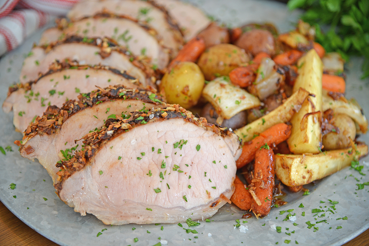 sliced pork loin on plate with veggies