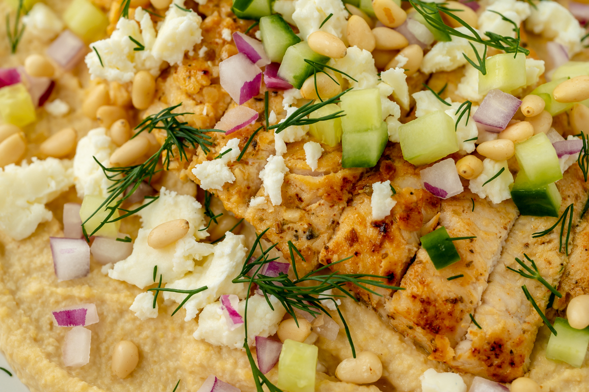 close up overhead shot of toppings on greek chicken hummus bowl