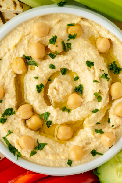 close up overhead shot of bowl of hummus with veggies