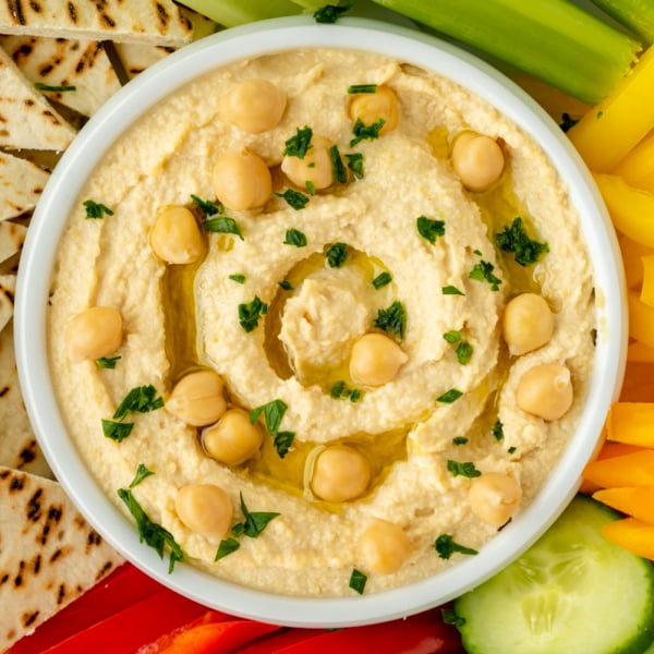 close up overhead shot of bowl of hummus with veggies