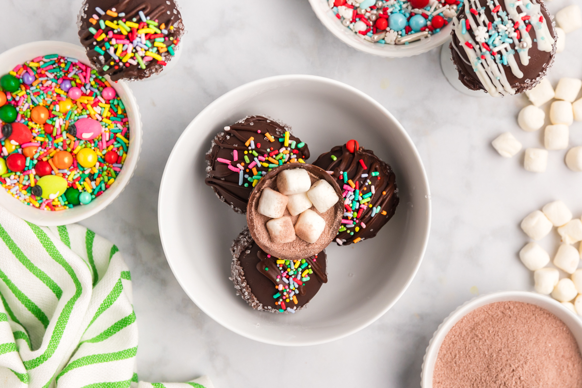 overhead shot of bowl of hot chocolate bombs with one cut open