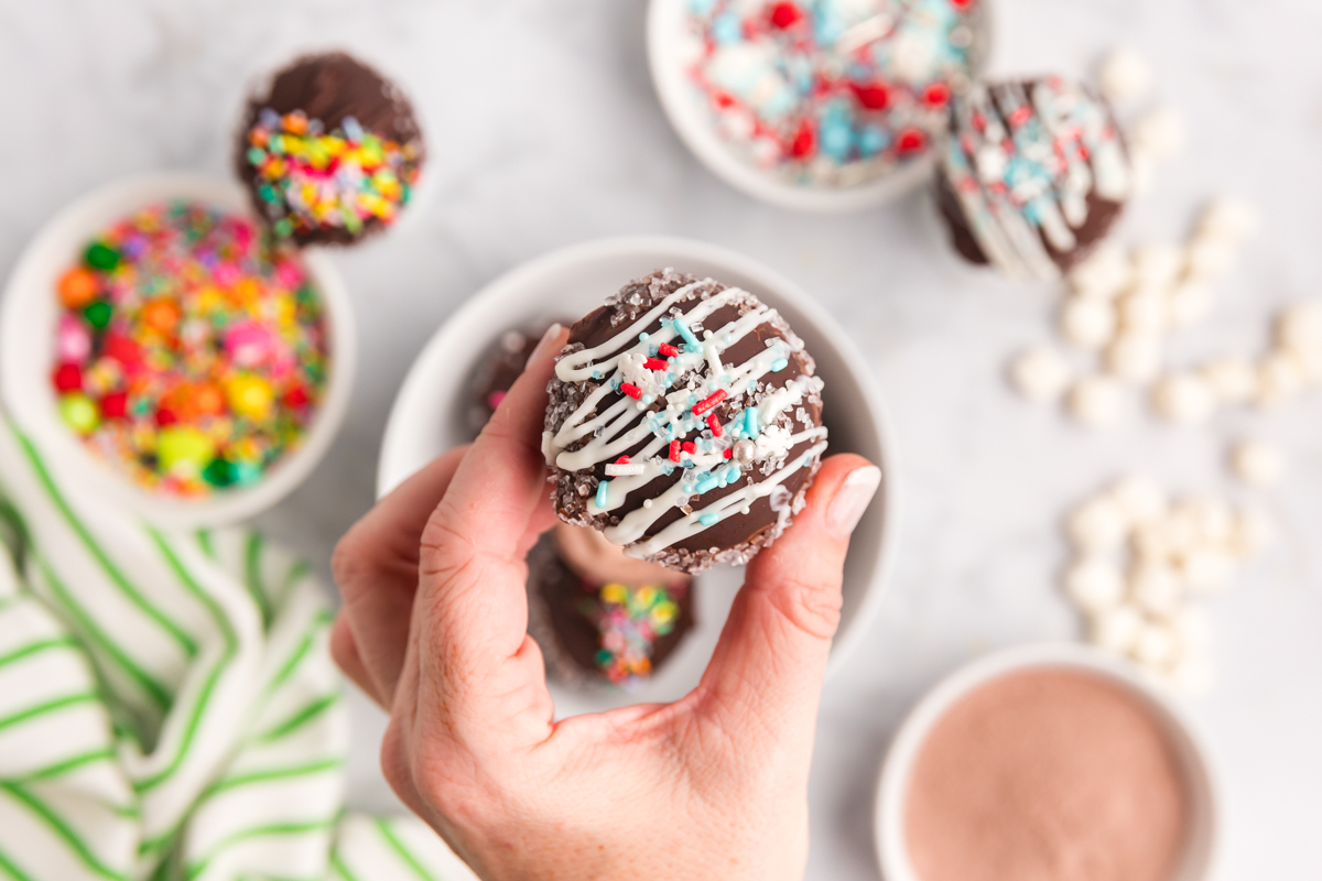 overhead shot of hand holding hot chocolate bomb