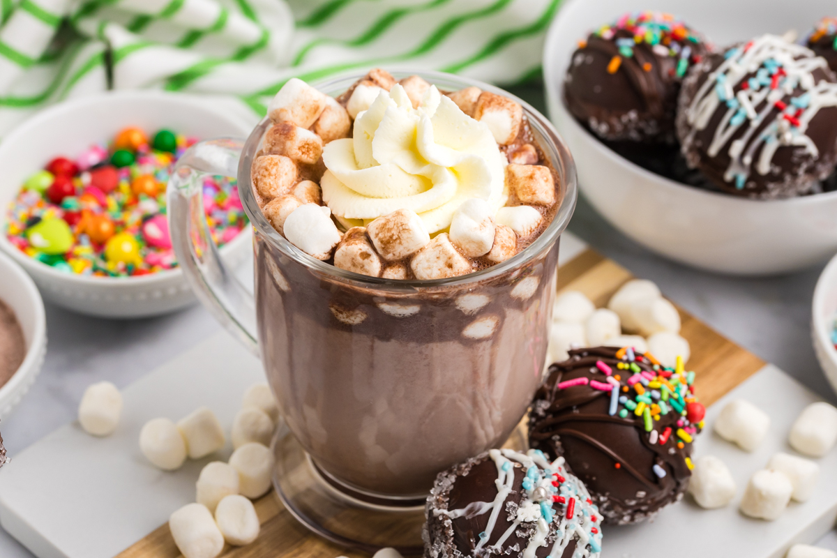 angled shot of whipped cream on mug of hot chocolate