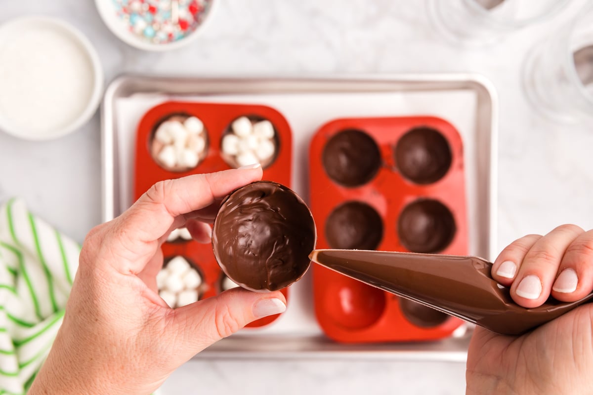 hand piping chocolate onto chocolate sphere