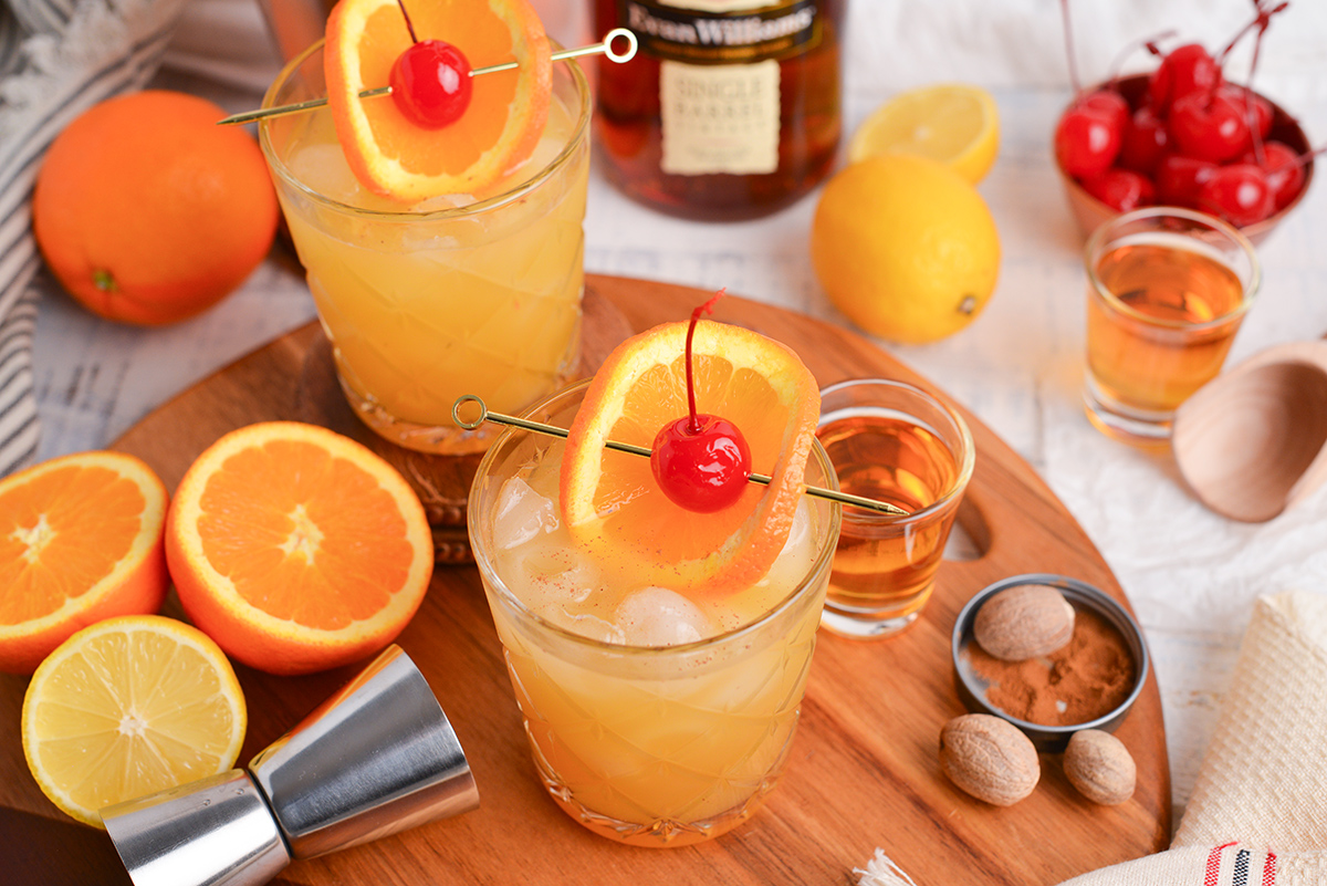 two maple whiskey sour cocktails on wooden board