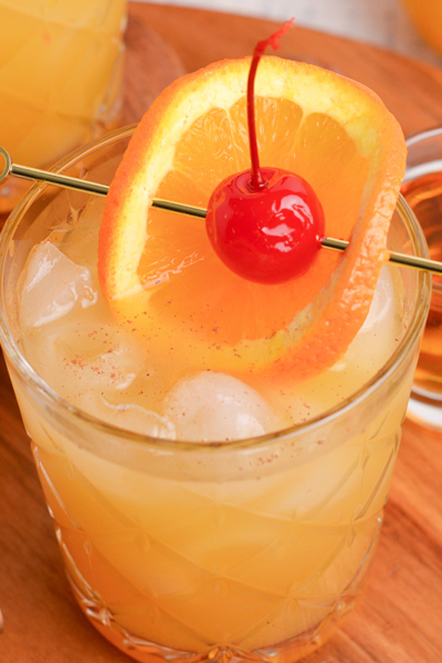 close up angled shot of maple whiskey sour on wooden board