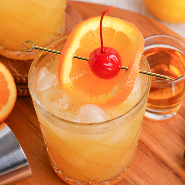 close up angled shot of maple whiskey sour on wooden board