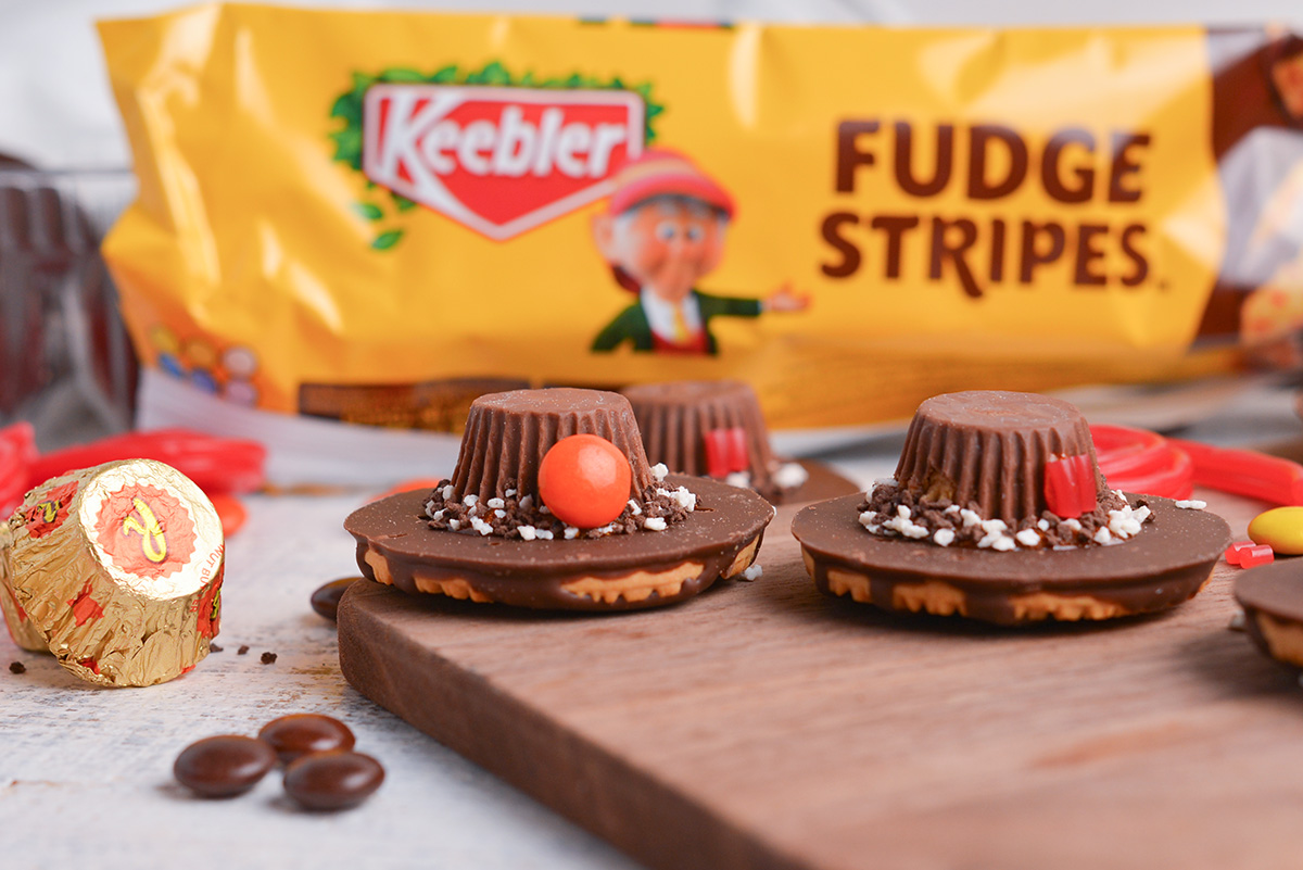 two pilgrim hat cookies on wooden board