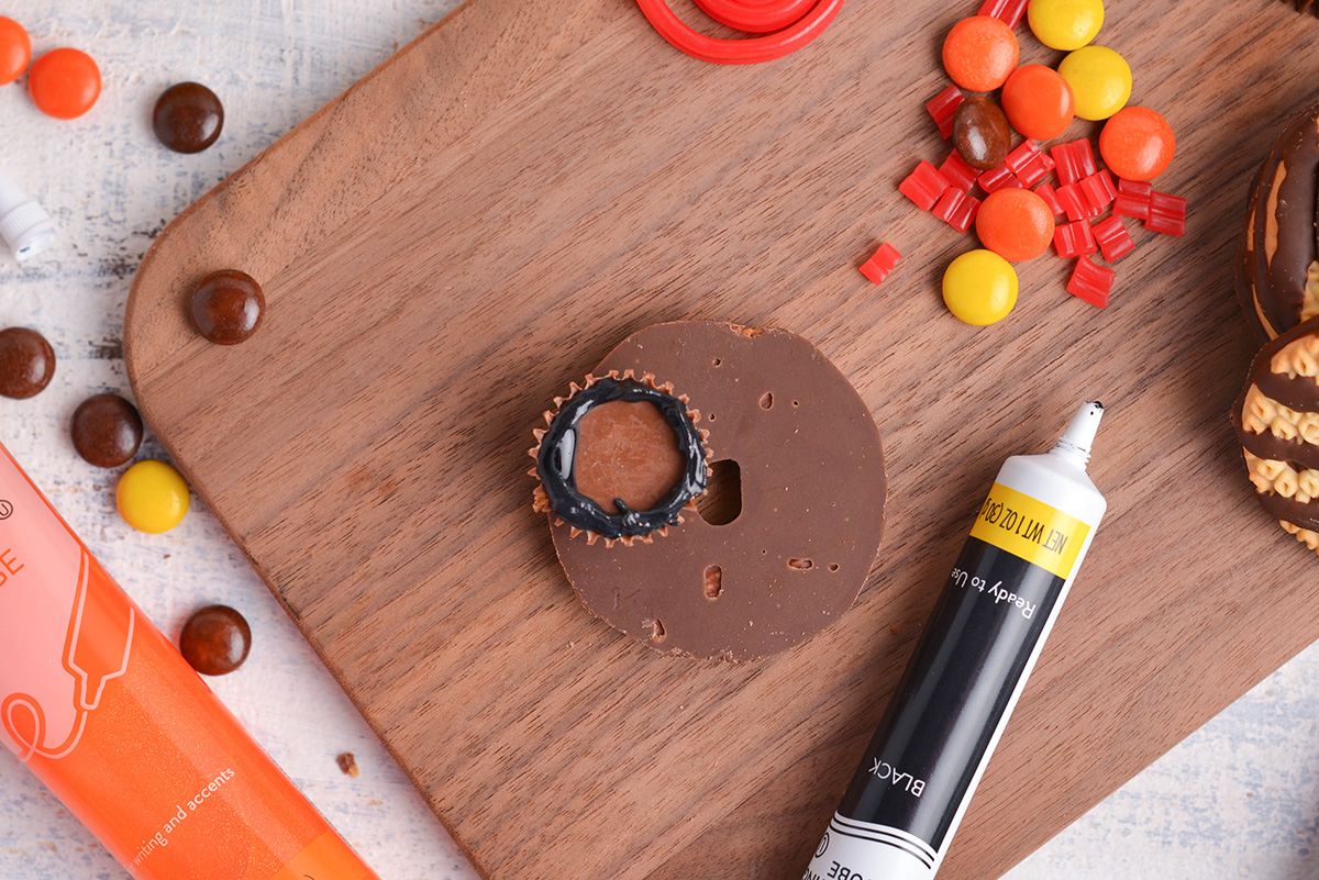 overhead shot of black icing piped around reese's cup