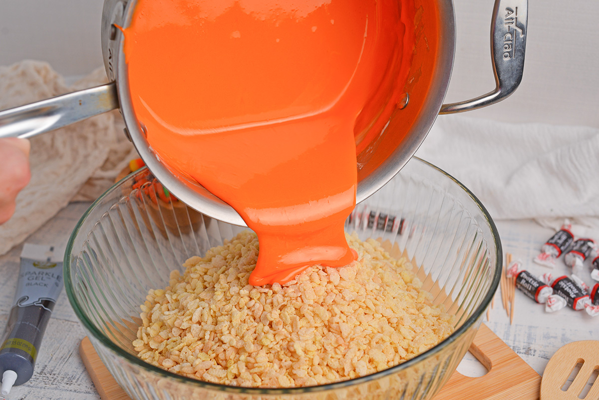 orange marshmallow mixture poured into rice krispies