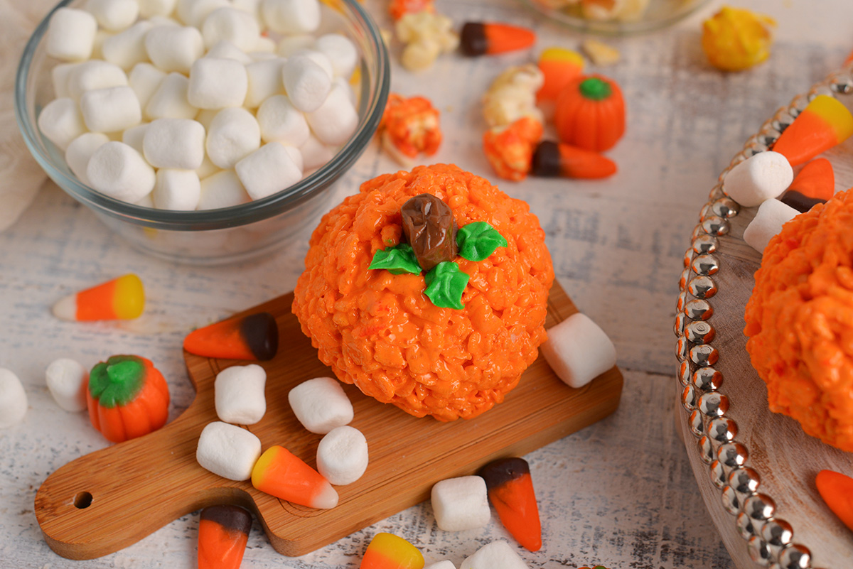 angled shot of pumpkin rice krispie treat on wooden board