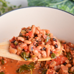 angled shot of black eyed peas on wooden spoon