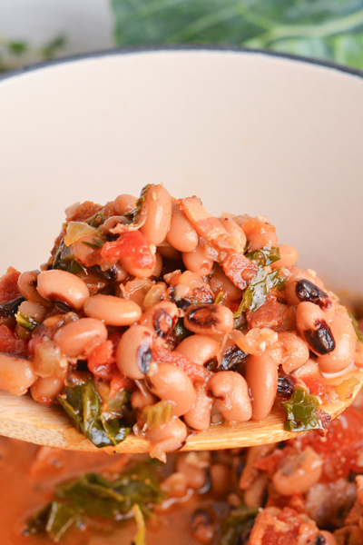 angled shot of black eyed peas on wooden spoon