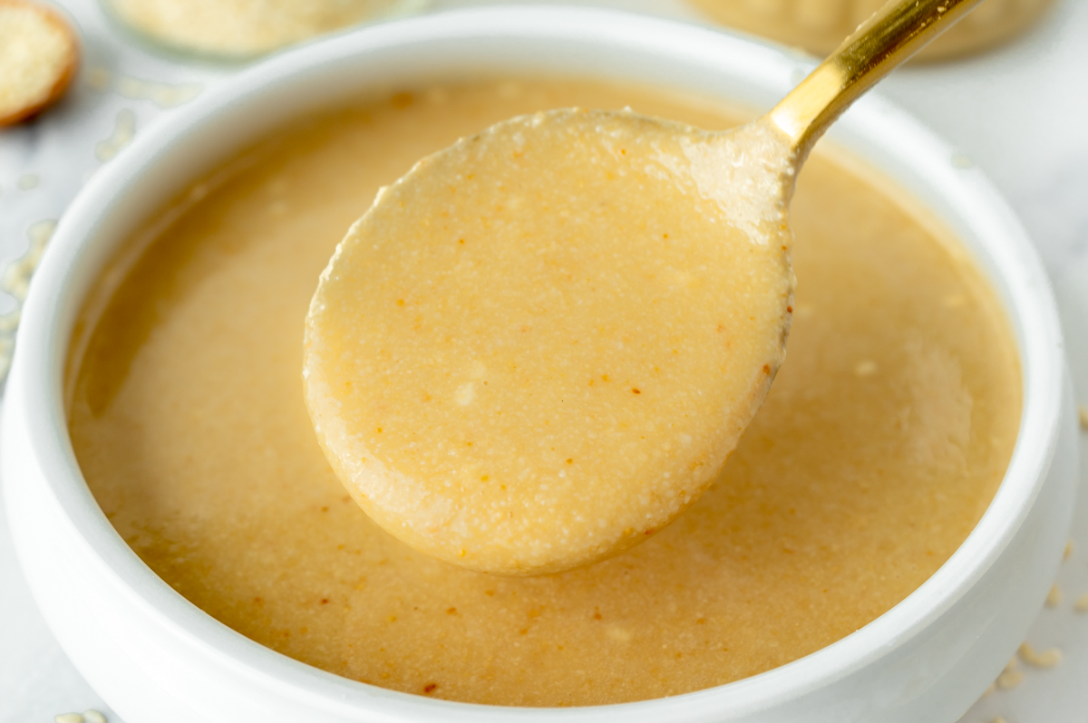 close up angled shot of spoon in bowl of tahini