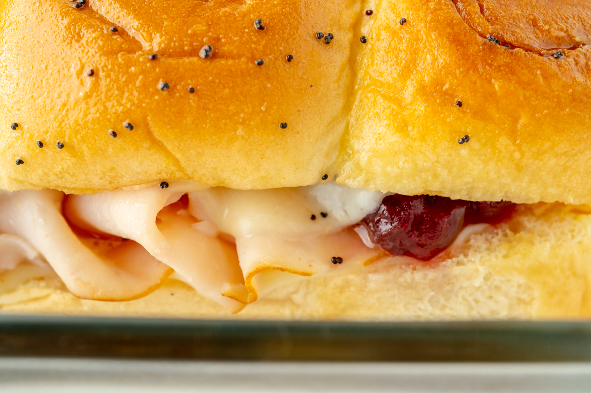 close up angled shot of cranberry turkey sliders in baking dish