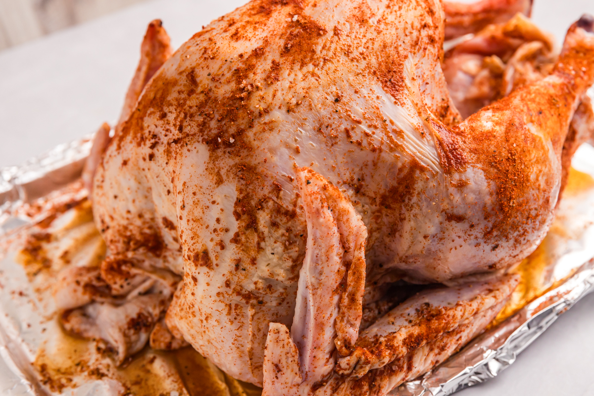 raw turkey coted with turkey rub