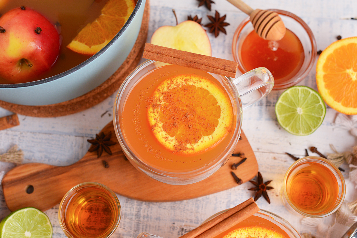 overhead shot of mug of wassail with cinnamon stick and orange slice