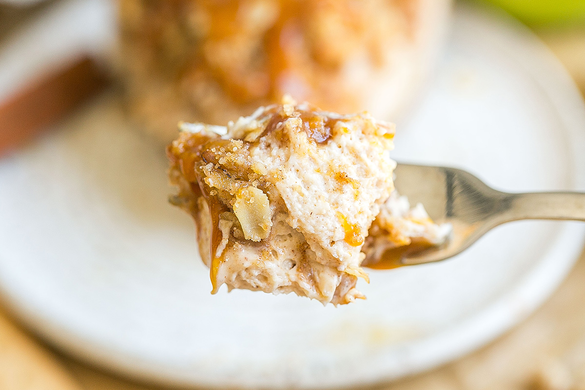 close up of bite of apple pie cheesecake on fork