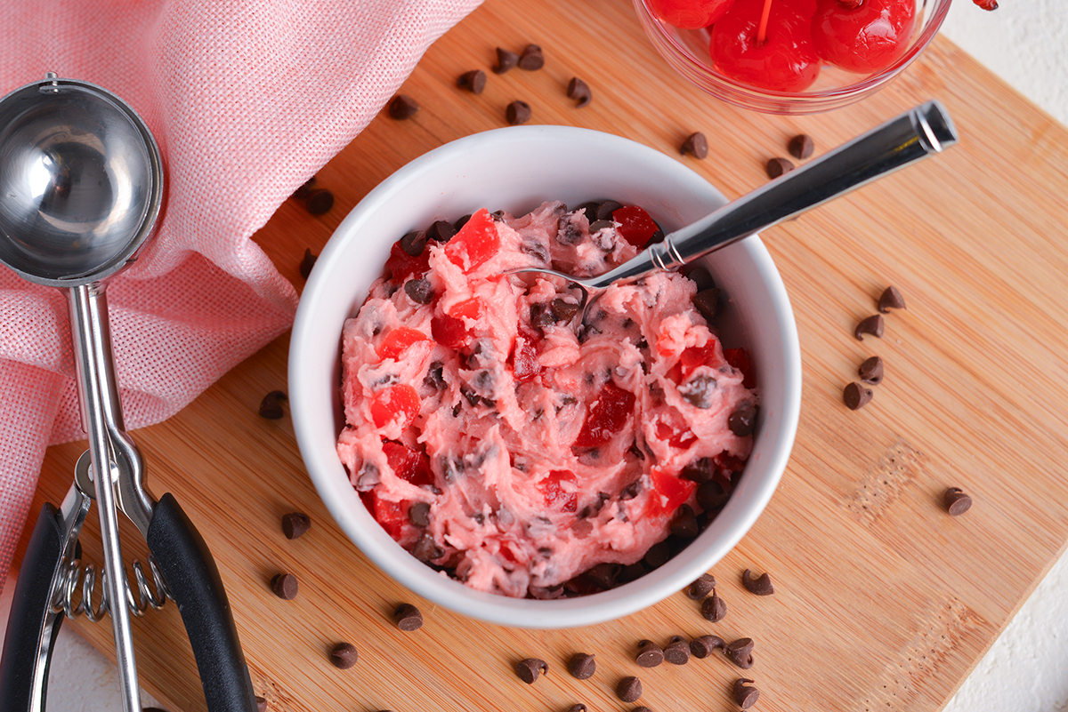 overhead shot of spoon in bowl of cherry chocolate cookie dough