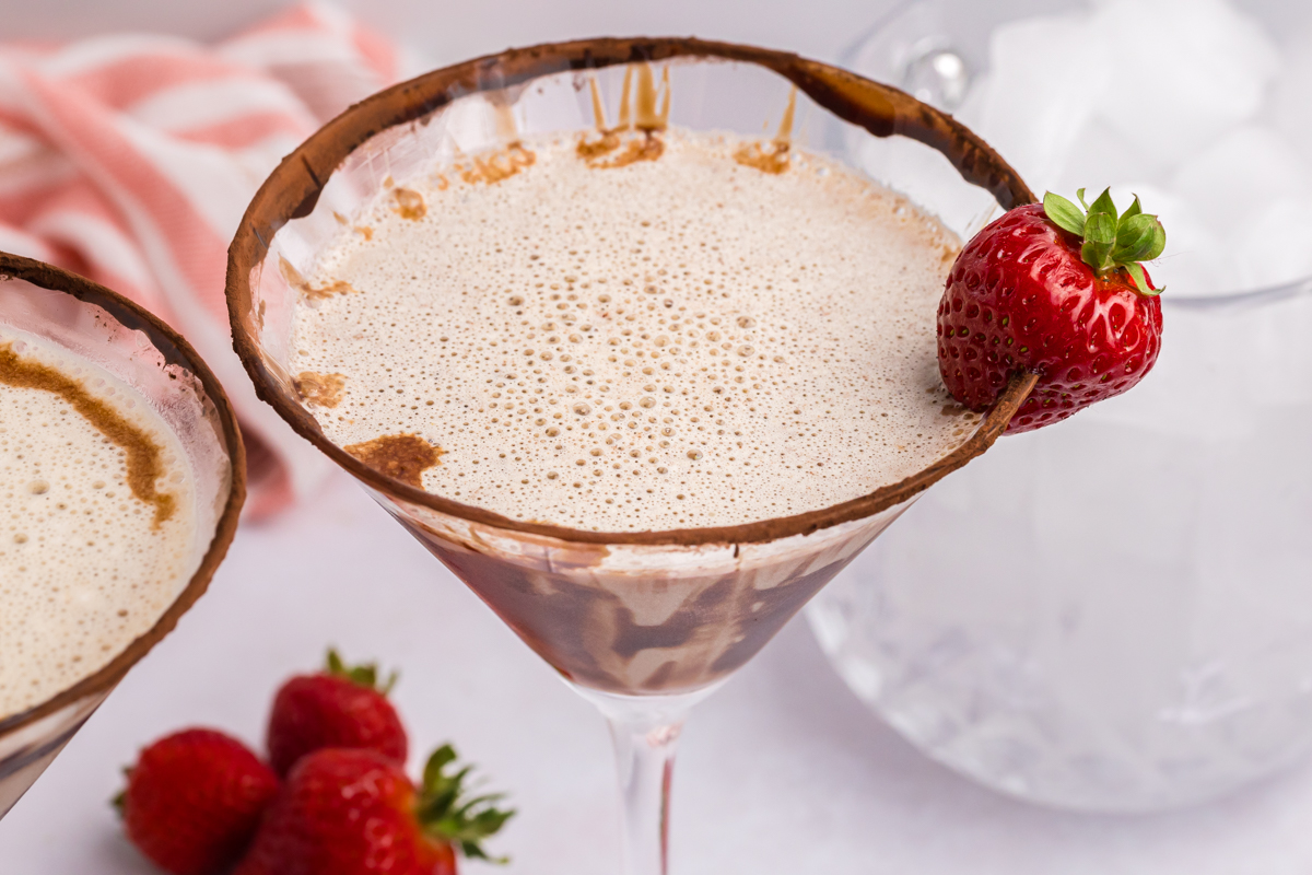 close up angled shot of strawberry on side of chocolate martini glass