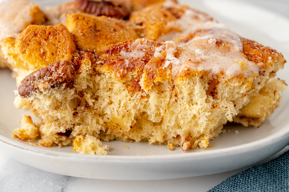 close up shot of bite taken out of scoop of cinnamon roll casserole