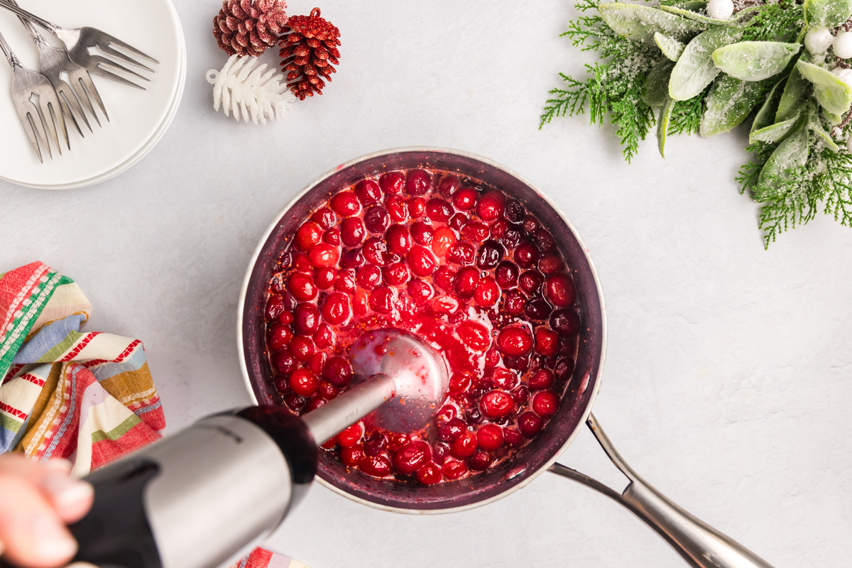 immersion blender in pan of cranberries