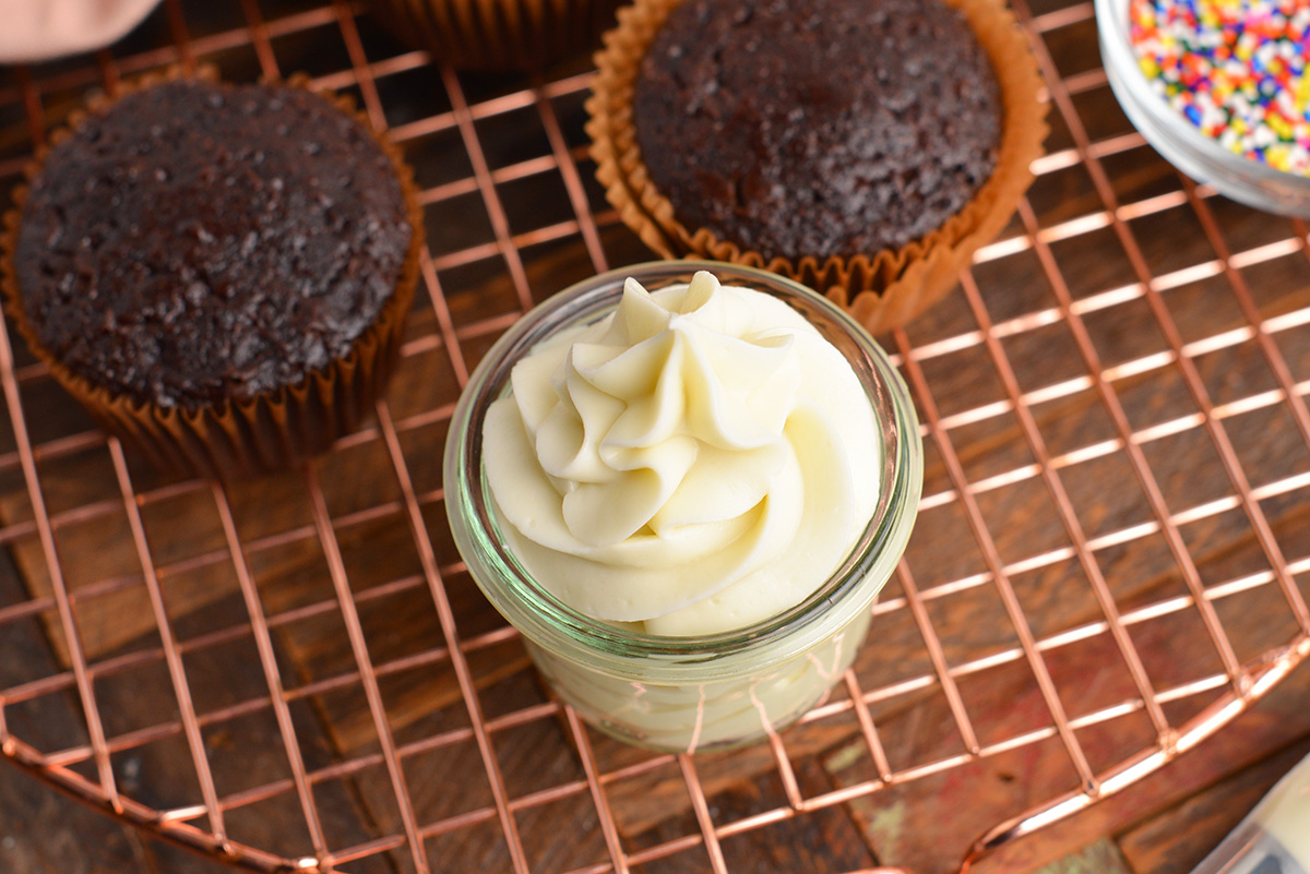 close up angled shot of cream cheese frosting in a jar