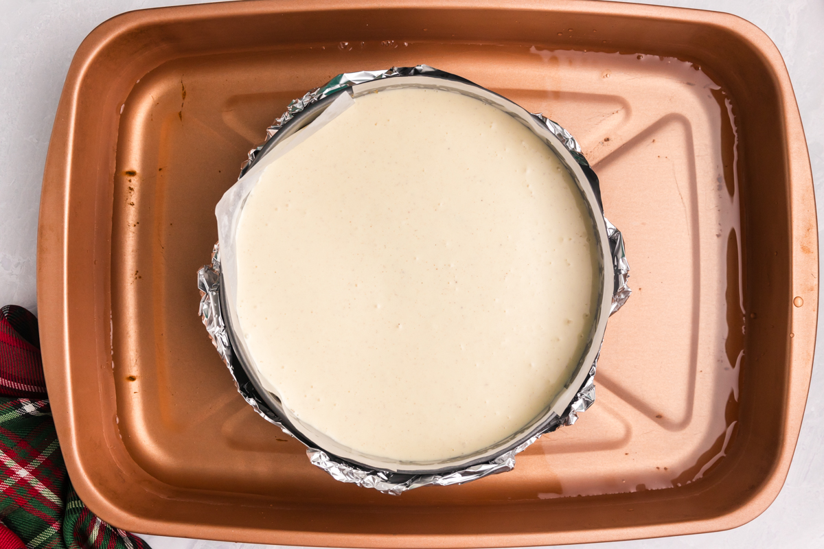 cheesecake batter poured into crust in water bath