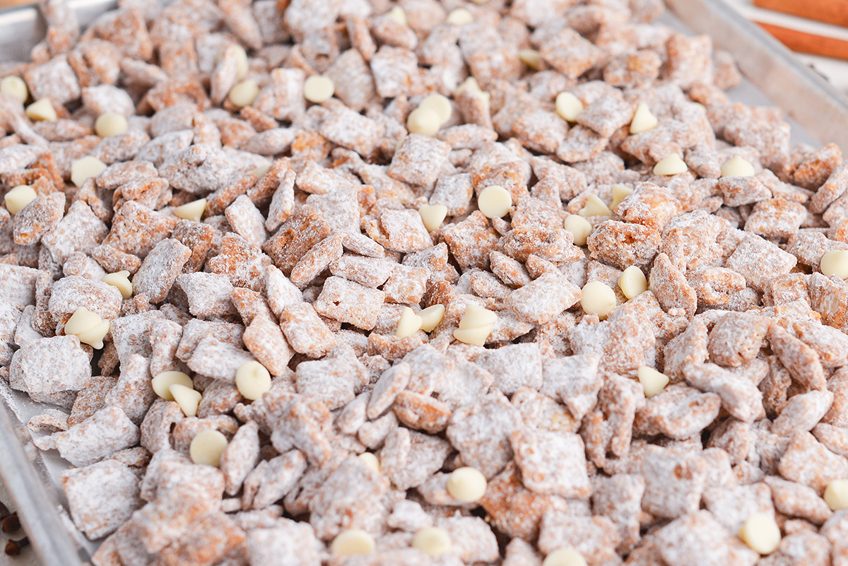 close up angled shot of gingerbread puppy chow on sheet pan