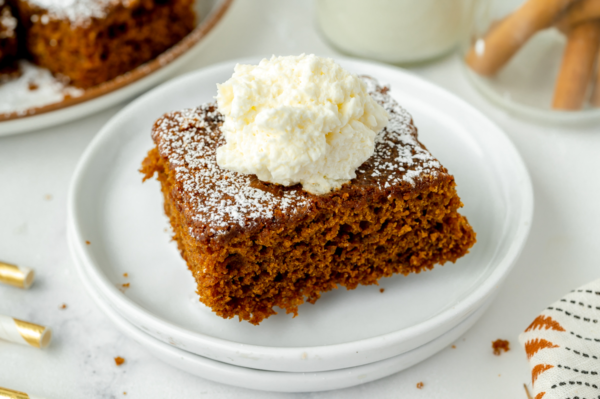 angled shot of slice of cake topped with whipped cream