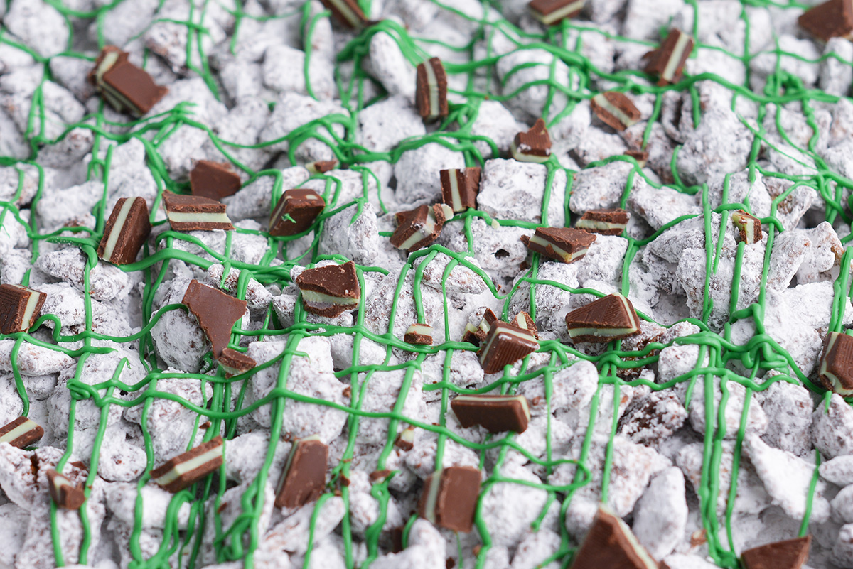 close up shot of baking sheet of mint chocolate chip muddy buddies