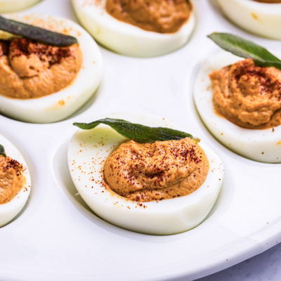 close up angled shot of platter of pumpkin deviled eggs