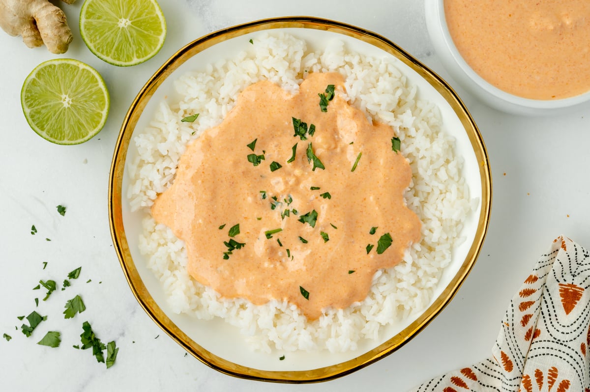 overhead shot of bowl of rice topped with red curry sauce