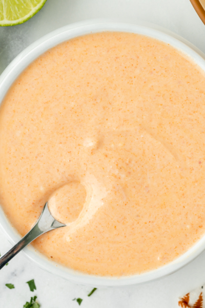 overhead shot of spoon in bowl of sauce