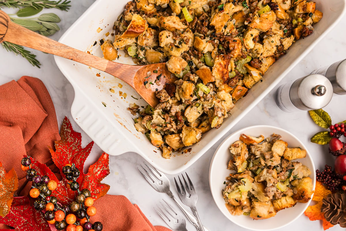 wooden spoon in baking dish of sausage dressing